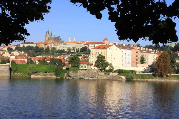 Kijk op de zonnige mindere stad van Praag met gotische burcht boven de rivier Moldau, Tsjechië — Stockfoto