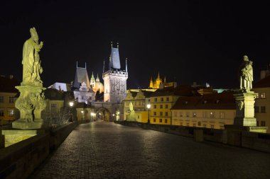 St. Nicholas Katedrali ve Charles Köprüsü 'nden kopan Köprü Kulesi ile Coronavirus, Çek Cumhuriyeti' nin Coronavirus döneminde insansız olan barok heykelleriyle dolu gece renkli Prag Gotik Kalesi.