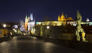 St. Nicholas Katedrali ve Charles Köprüsü 'nden kopan Köprü Kulesi ile Coronavirus, Çek Cumhuriyeti' nin Coronavirus döneminde insansız olan barok heykelleriyle dolu gece renkli Prag Gotik Kalesi.