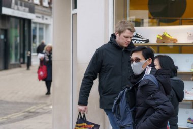 Siyah saçlı ve gözlüklü Asyalı bir adam gri bir maske takıyor, York, Kuzey Yorkshire, İngiltere, İngiltere.