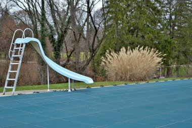 Bahçe yüzme havuzu, tramplenli ve havuz kaydırağlı. Kış için katmanlı ve kapalı.