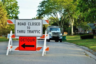 Yol trafiğe kapalı. Bir yerleşim bölgesinde inşaat tabelası var.