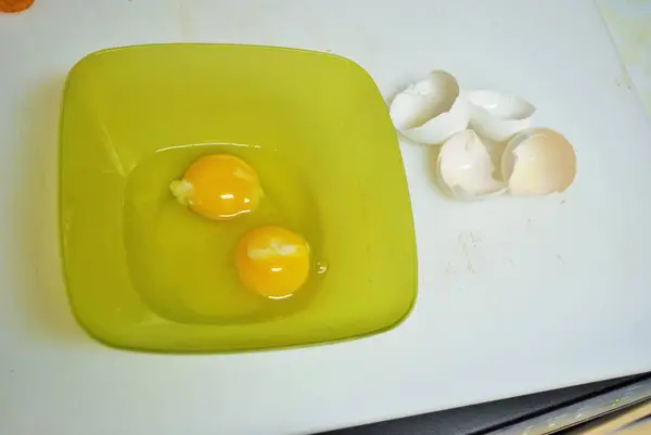 Nahaufnahme Von Zwei Rohen Eiern Einer Grünen Plastikschüssel Und Eierschalen — Stockfoto