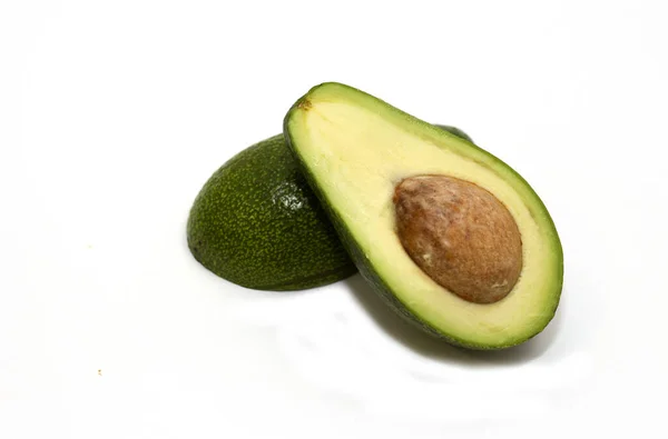 Twee sneetjes verse biologische avocado geïsoleerd op een witte achtergrond. Een stuk met kern. Design element voor product label, catalogus print, web gebruik. Tropisch exotisch voedsel. — Stockfoto