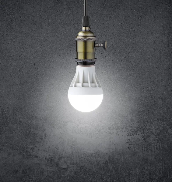 Светящаяся светодиодная лампа на гранж-стене — стоковое фото