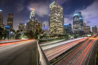 Downtown Los Angeles at night with car traffic light trails clipart