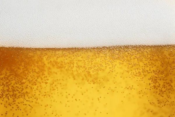 Fechar a cerveja com espuma e bolhas — Fotografia de Stock