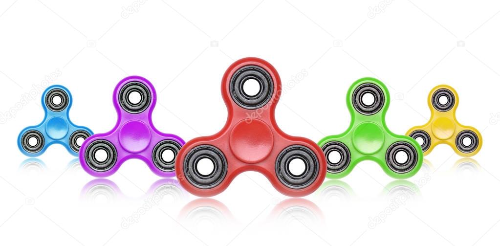 Row of colorful fidget spinners. Stress relieving toy isolated o