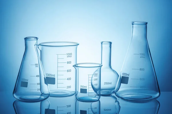 蓝色背景反射的实验室玻璃器皿 — 图库照片