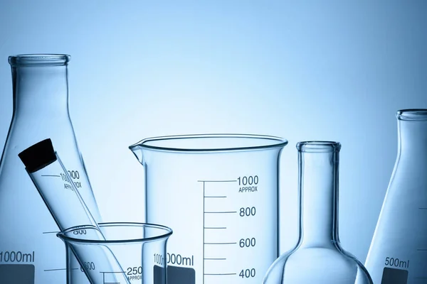 Conjunto de vidro de laboratório com reflexões sobre fundo azul — Fotografia de Stock