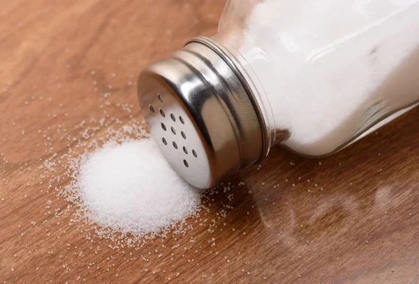 Соляной шейкер на деревянном столе — стоковое фото