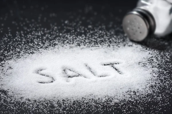 Ordet salt skrevet ind i en bunke salt - Stock-foto