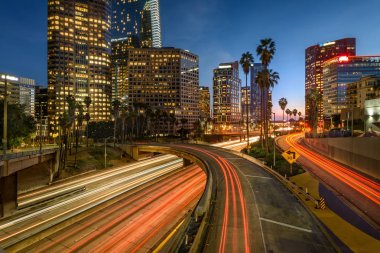 Downtown Los Angeles at night with car traffic light trails clipart