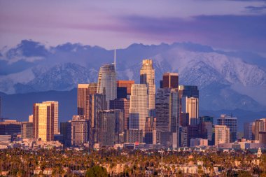 Şehir Los Angeles siluetinin arkasında karla kaplı dağlar