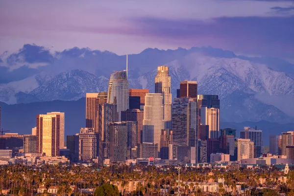 Skyline van Los Angeles met besneeuwde bergtoppen achter een — Stockfoto