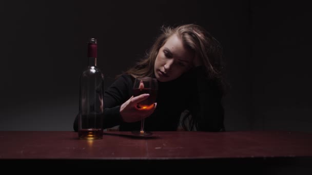 年轻美丽的女人在严重的抑郁症 虐待和酗酒的概念 酒精中毒的女人带着酒瓶和酒杯 — 图库视频影像