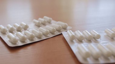 Tablet ve hapları masaya bırakıyorum. İlaçlara, tabletlere, vitaminlere, ilaçlara, kapsüllere, ilaçlara ve sağlık hizmetleri için gıda takviyelerine odaklanın. İlaçlar. İlaç endüstrisi.. 