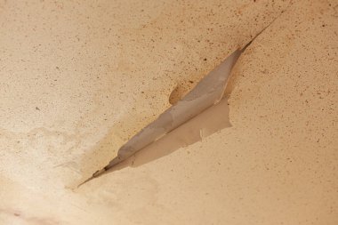 Çatı sızıntısı yüzünden tavandaki boyayı soymak. Sızdıran bir borunun yol açtığı su hasarlı tavan vasıfsız bir tesisatçı tarafından tamamlanmış. Ev sigortası talebi..