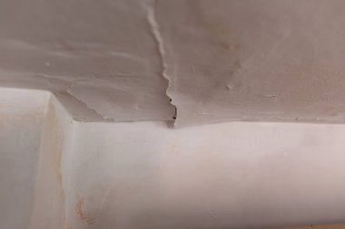 Çatı sızıntısı yüzünden tavandaki boyayı soymak. Sızdıran bir borunun yol açtığı su hasarlı tavan vasıfsız bir tesisatçı tarafından tamamlanmış. Ev sigortası talebi..