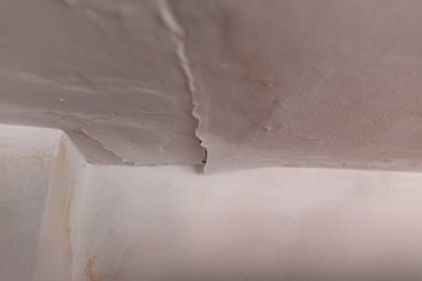 Çatı sızıntısı yüzünden tavandaki boyayı soymak. Sızdıran bir borunun yol açtığı su hasarlı tavan vasıfsız bir tesisatçı tarafından tamamlanmış. Ev sigortası talebi..