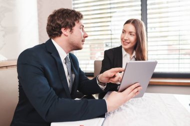 Genç iş kadını ve işadamı tablet ve belge kullanıyor, mali durumları hakkında konuşuyorlar..