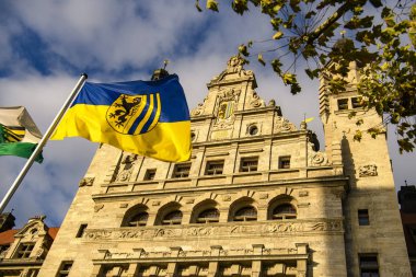 Leipzig, Almanya 'nın Leipzig şehrinin tarihi bölümünde, binanın önünde Leipzig bayrağı taşıyan New City Hall Neues Rathaus. 2019