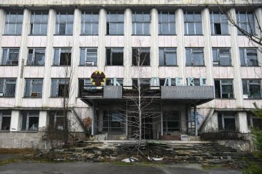 Terk edilmiş hayalet kasaba Prypiat. Aşırı büyümüş ağaçlar ve Chornobyl sınırlama bölgesinde yıkılan binalar. Aralık 2019