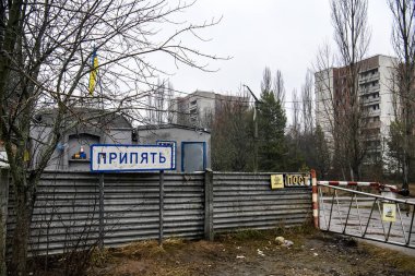Chornobyl Yasaklama Bölgesi 'ndeki hayalet şehir Prypiat' ın girişindeki kontrol noktasının yanındaki Pripyat tabelası. Aralık 2019