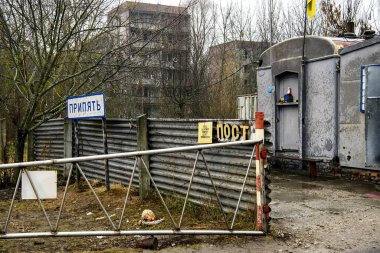 Chornobyl Yasaklama Bölgesi 'ndeki hayalet şehir Prypiat' ın girişindeki kontrol noktasının yanındaki Pripyat tabelası. Aralık 2019