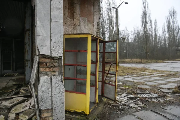 Sovjet gele telefooncel op straat van verlaten spookstad Pripyat, Chornobyl uitsluitingszone. december 2019 — Stockfoto