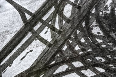 Karla kaplı asfaltta araba lastiği izleri var..