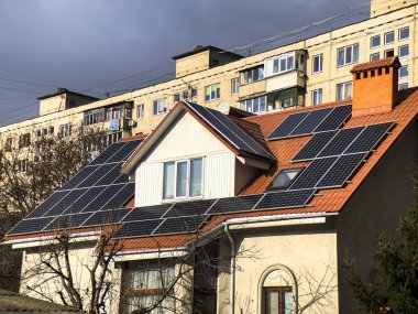 Kulübe çatıda güneş panelleri ve arkadaki apartman ile donatılmıştır. Ukrayna.