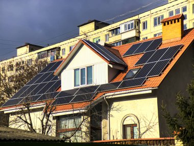 Kulübe çatıda güneş panelleri ve arkadaki apartman ile donatılmıştır. Ukrayna.