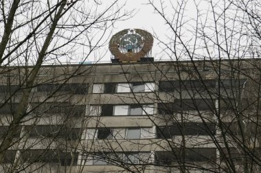 Sovyetler Birliği arması Çernobil nükleer santrali yakınlarındaki terk edilmiş Prypiat 'ta inşa ediliyor. Ukrayna.