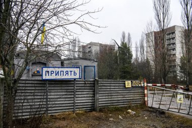 Pripyat, Ukrayna 'nın Chornobyl Yasaklama Bölgesi' ndeki hayalet şehir Prypiat 'ın girişindeki kontrol noktasının yanındaki işaret levhası.. 