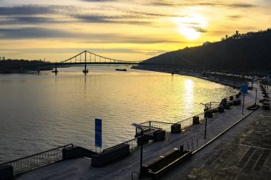 Kyiv 'deki Dnipro Dinyeper Nehri seti üzerinde gün doğumu. Arka planda yaya köprüsü var. Kyiv, Ukrayna. 