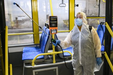 Tramvay parkının çalışanı Coronavirus COVID-19 'a karşı tramvay kulübesini dezenfekte ediyor. Kyiv, Ukrayna