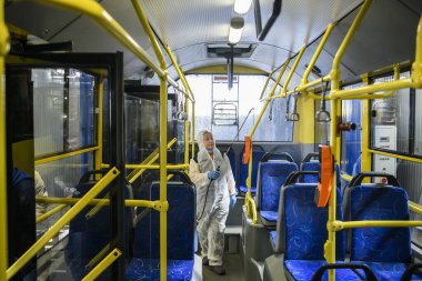 Tramvay parkının çalışanı Coronavirus COVID-19 'a karşı tramvay kulübesini dezenfekte ediyor. Kyiv, Ukrayna