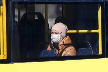 Koronavirüs COVID 19 'a karşı koruyucu bir önlem olarak koruyucu maske takan toplu taşıma yolcusu. Kyiv, Ukrayna. 