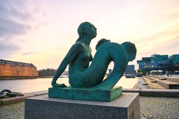 Evening view to Mermaid sculpture outside the Black Diamond Royal Danish Library in Copenhagen, Denmark.