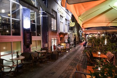 Danimarka 'nın Kopenhag kentindeki Nyhavn liman kanalındaki renkli eski evlerdeki kafelerin akşam manzarası. 