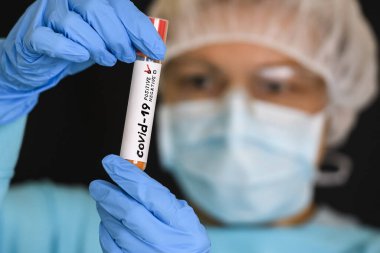 Koruyucu giysili kadın test tüpü tutuyor ve Coronavirus COVID virüsü kapmış. 19. Fotoğraf Çizimi.
