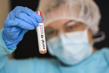 Koruyucu giysili kadın test tüpü tutuyor ve Coronavirus COVID virüsü kapmış. 19. Fotoğraf Çizimi.