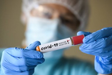 Koruyucu giysili kadın test tüpü tutuyor ve Coronavirus COVID virüsü kapmış. 19. Fotoğraf Çizimi.
