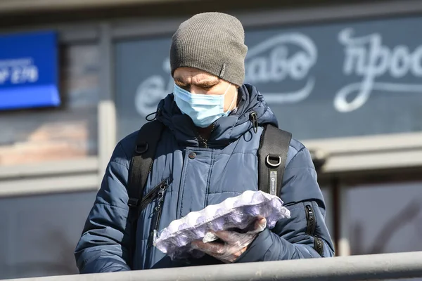 Людина, одягнена в захисну маску, як запобіжний захід проти коронавірусу COVID 19 на вулиці. Київ, Україна. Березень 2020 — стокове фото