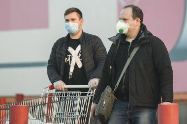 Koronavirüs COVID 19 'a karşı önleyici bir önlem olarak koruyucu maskeler takan insanlar Ukrayna' nın başkenti Kyiv 'de caddede.