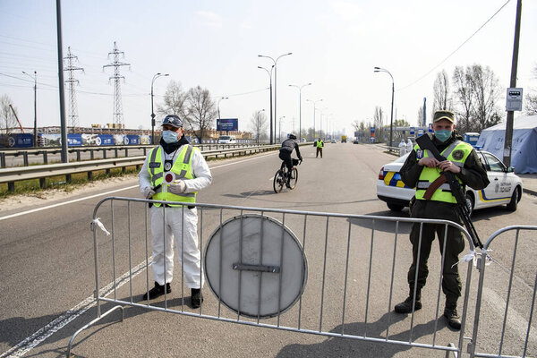 Policemen and national guards is stand at a checkpoint during disease COVID-19 outbreak in Kyiv, Ukraine. 