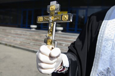 Koronavirüs COVID 'e karşı önleyici önlem olarak koruyucu eldivenler giymiş Ortodoks Rahibi - 19 kişi çarmıha gerildi.