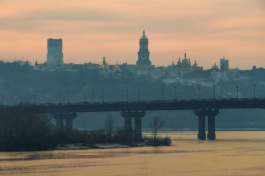 Paton köprüsü ve Kyiv Pechersk Lavra çan kulesi ve Lavra ortodoks kilise kubbeleri ve gün batımında manastır silueti.