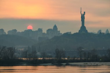 Gün batımında Dinyeper Nehri 'nin, Anavatan Anıtı' nın ve Kyiv 'in sağ yakasının üzerinden sol kıyıya bakın. Ukrayna.